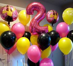 the number two is surrounded by balloons in pink, black, and yellow color scheme