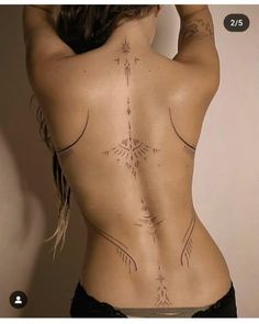 the back of a woman's body with tattoos on her upper and lower back