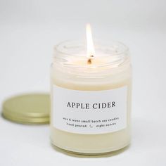 an apple cider candle sitting on top of a white table