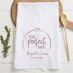 the perfect mix tea towel on a cutting board next to a wooden spoon and sprig of rosemary