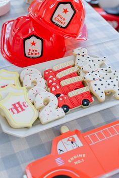 decorated cookies and fireman hats are sitting on a table in front of other items