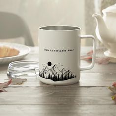 a white coffee mug sitting on top of a wooden table