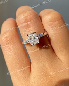 a woman's hand with a diamond ring on top of her finger and an engagement band