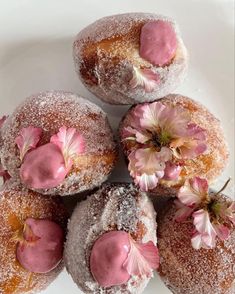 four powdered donuts with pink frosting and flowers