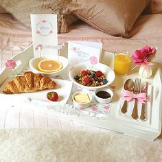 a tray with breakfast food on top of a bed next to a cup of coffee