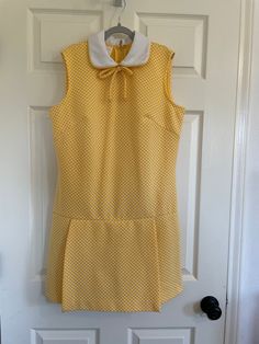 Vintage 70s skort dress in yellow/white polyester doubleknit with back zipper.  Features peter pan collar and bow tie at neck.  Excellent condition. Vintage size 14.  Best for modern size M.  Please see measurements and compare to a similar garment in your closet. Length 35" Shoulder to crotch 32" Shoulders 14 3/4" PTP 19 1/4" Waist 17 1/2" Hip 21" At this time standard shipping is a flat fee to the United States only.  Additional items ship for only one dollar.  To place an order to outside the Retro Fitted School Dress, Retro Fitted Dress For School, Yellow School Dress For Spring, Yellow Spring Dresses For School, Addams Family Musical, Skort Dress, 1970s Fashion, One Dollar, Pan Collar