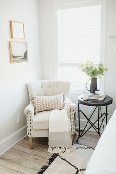 a white chair sitting next to a window in a room