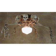 a ceiling light with skulls and bones on it's arms hanging from the ceiling