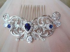 a bridal hair comb with blue and white stones on it's headpiece