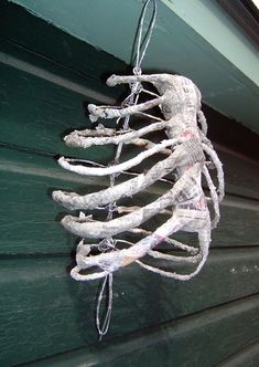 a skeleton hanging from the side of a building