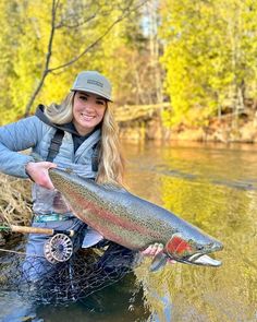 a woman holding a large fish in the water