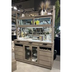 a display case with glass doors and shelves filled with dishes, vases and other items