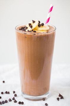 a smoothie with bananas and chocolate chips on the top is ready to be eaten