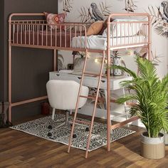 a pink metal bunk bed next to a potted plant in a room with wallpaper