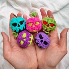 four crocheted skulls are in the palm of someone's hand