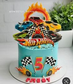 a birthday cake decorated with hot wheels and flames