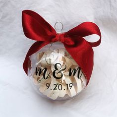 a glass ornament with a red ribbon on it that says mr and mrs