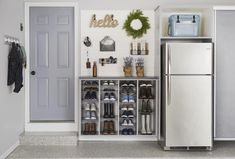 a white refrigerator freezer sitting inside of a kitchen next to a wall mounted shoe rack