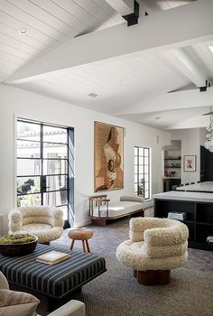 a living room filled with furniture and a chandelier hanging over the top of it