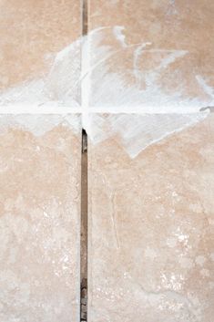 an orange and white cat laying on top of a tile floor next to a knife