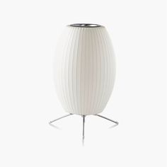 a white vase sitting on top of a metal stand