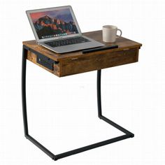 an open laptop computer sitting on top of a wooden desk next to a coffee cup