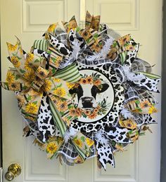 a wreath is hanging on the front door with sunflowers and cow's head