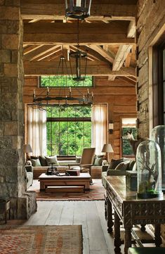 a living room filled with furniture and a large window covered in wood planked walls