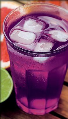 a purple drink with ice and lime slices