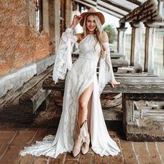 a woman in a white dress and cowboy hat posing for a photo on a bench