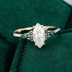 a diamond ring sitting on top of a green cloth