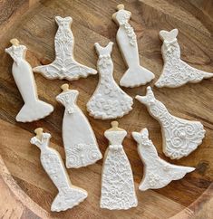 decorated cookies in the shape of brides and grooms on a wooden platter