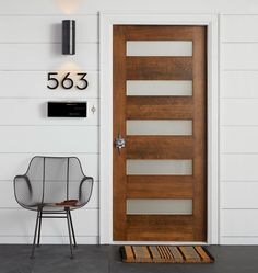 the front door to a house with a chair next to it