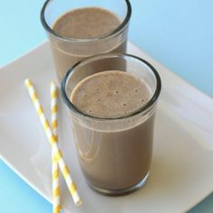 two glasses of chocolate milkshakes on a plate