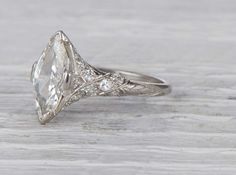 an antique style engagement ring with a pear shaped diamond