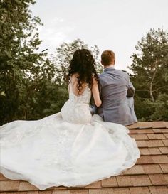 a bride and groom are sitting on the roof