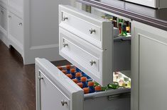 an open drawer in a kitchen filled with drinks