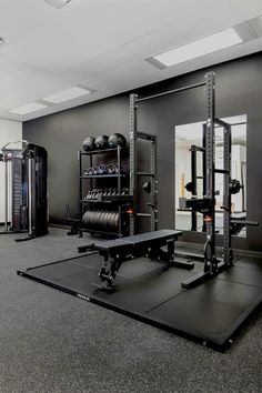 an empty gym with equipment and mirrors