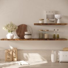 two wooden shelves above a kitchen counter with various items on it and a microwave in the background