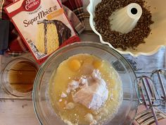 ingredients to make cake sitting in bowls on a wooden table next to baking utensils