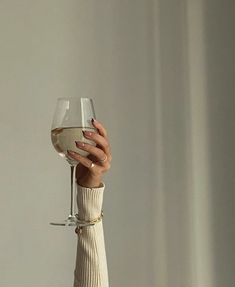 a woman holding a wine glass in her hand