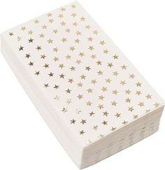 a stack of white and gold paper with stars on it