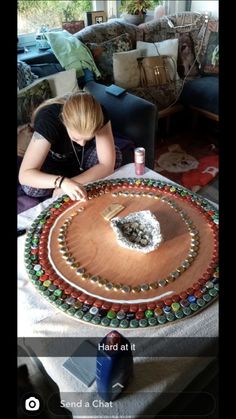 a woman sitting at a table with a large cake on it's side and the words hand at it in front of her face