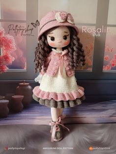 the doll is wearing a pink hat and dress