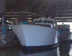 two boats are docked in the water under an overhanged area at a dock