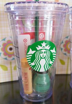 two starbucks cups sitting next to each other on a table