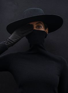 a woman wearing a black hat and gloves