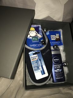 an open box containing men's grooming products and toiletries on a bed