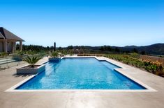 an empty swimming pool in front of a house