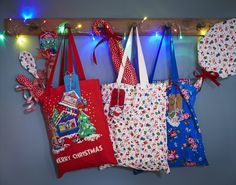 several christmas themed bags hanging on a wall